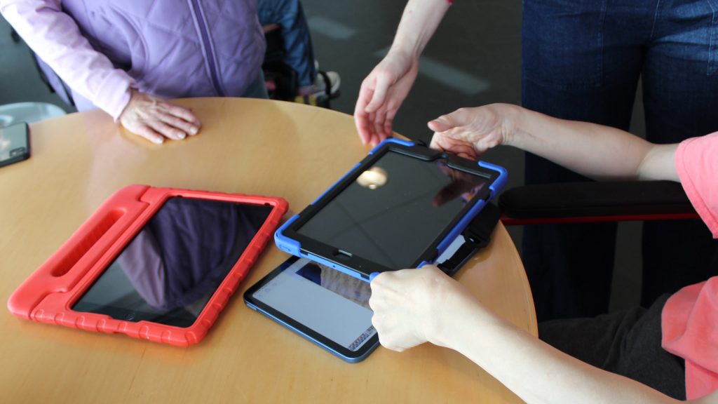 hands picking up tablets on a table